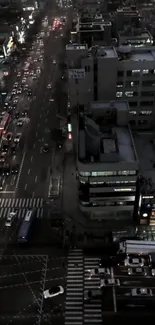 Aerial view of city streets at night with illuminated buildings.