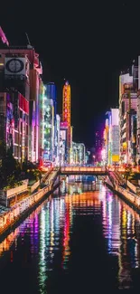 Vibrant city nightscape with neon lights and water reflections.