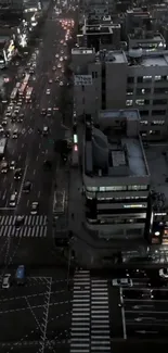 Night cityscape with busy streets and illuminated buildings viewed from above.