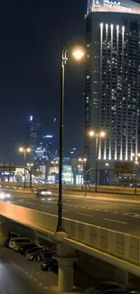 Night cityscape with illuminated skyscrapers and urban street scene.