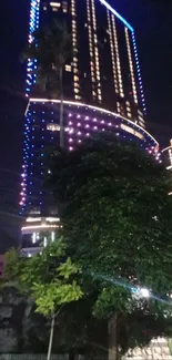 City skyscraper lit with colorful night lights.