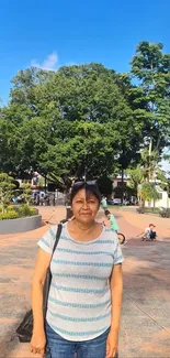 A serene park scene with lush trees and a person in the foreground.