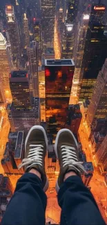 Feet dangling above brightly lit cityscape at night.