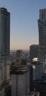 A city skyline with modern skyscrapers against a dusk sky.