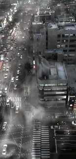 Aerial view of a bustling city street at night with foggy atmosphere.