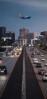 Airplane flying over city highway at twilight with lights on.