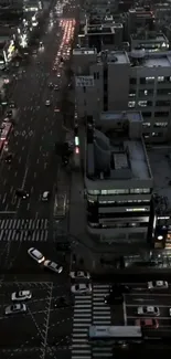 Aerial view of city streets at night with traffic and lights.