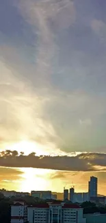 City skyline with sunrise and clouds over a blue sky.