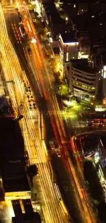 Aerial view of city streets lit up at night, showcasing vibrant traffic lights.