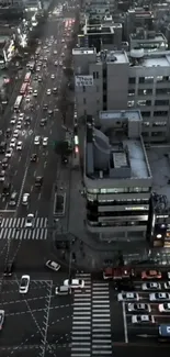 Aerial view of city streets at dusk with traffic and lit buildings.