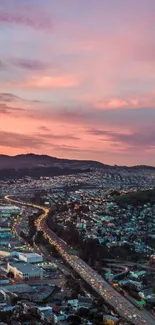 Scenic cityscape at dusk with vibrant pinkish sky and illuminated streets.