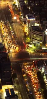 Aerial view of a vibrant, illuminated city intersection at night.