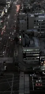 Aerial view of a cityscape at night with busy streets and illuminated buildings.