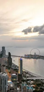 Sunset over city skyline with ocean view and ferris wheel.