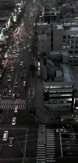 Aerial view of city street at night, bustling with traffic and lights.