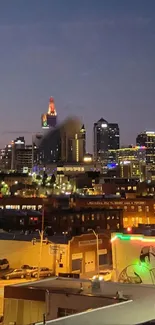 Evening cityscape with skyline and colorful lights against a dusky sky.