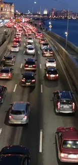 Nighttime city traffic on riverside road with glowing car lights in vibrant scene.