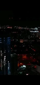 Night cityscape with glowing lights and tall buildings.