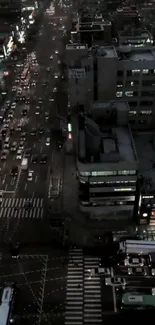 Aerial cityscape with traffic and lights at night from above.