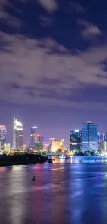 Serene city skyline at night reflected on calm water, with vibrant urban lights.