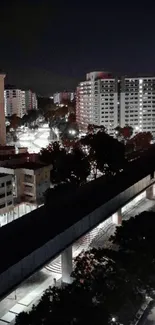 Nighttime cityscape with lit buildings and dark sky.