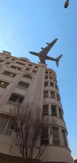 Airplane flying over urban building with blue sky.