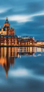 Cityscape night with building reflected in calm waters, showcasing serene beauty.