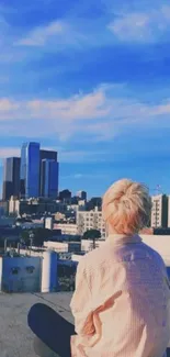 Person sitting on a rooftop with blue sky and cityscape in the background.