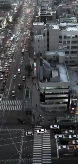 Aerial view of a busy city street intersection with heavy traffic and high-rise buildings.