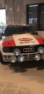 Classic Audi rally car with red and white livery in museum.