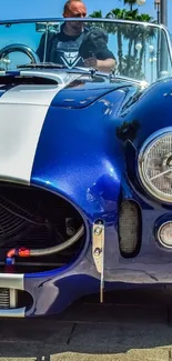 Front view of a vintage blue sports car, perfect for wallpaper.