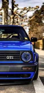 Vintage blue car on scenic road wallpaper.