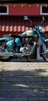 A classic blue motorcycle parked in front of a rustic background.