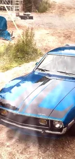 Mobile wallpaper featuring a vintage blue muscle car on a gravel road.