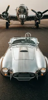 Vintage car on runway with aircraft in background.