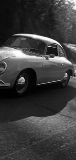 Black and white mobile wallpaper of a classic car on a road.