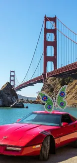 Red car parked near Golden Gate Bridge with a butterfly ornament.