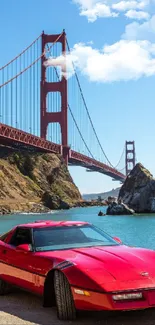 Red classic car parked near the Golden Gate Bridge under a clear blue sky.