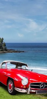 Classic red car on grassy beach with ocean view.