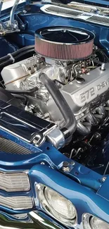 A detailed view of a classic car engine with chrome accents in a blue vehicle.