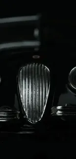 Front view of a classic car in black, creating a sleek and mysterious wallpaper.