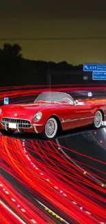 Vintage red car on neon-lit highway at night.