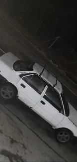 A classic white car parked on a dark road at night.