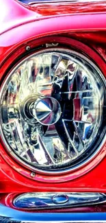 Close-up of a vintage car's red headlight with reflective details.