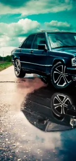 Vintage car on wet road reflecting in puddle, under a teal sky.