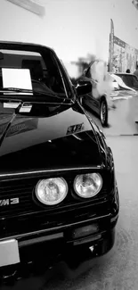 Black and white wallpaper featuring a classic car at a show.