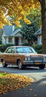 Classic car on a leafy autumn street with vibrant trees and houses.