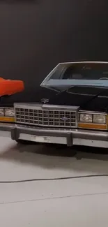 Classic cars in a modern showroom featuring a black and orange vehicle.