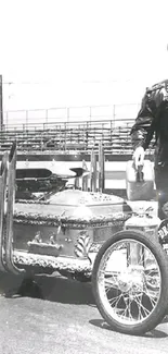 Black and white classic hot rod with a leather-jacketed driver at a drag strip.