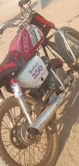 Classic Bullet 350 motorcycle on sandy terrain.